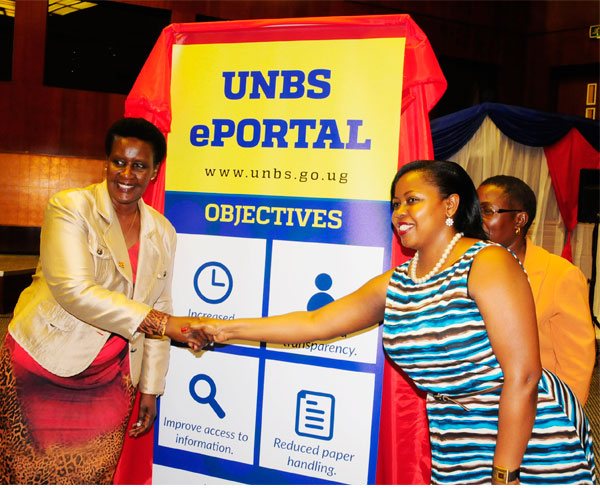 Left; Uganda Minister of Trade, Industry and Cooperatives Hon. Amelia Kyambade and right; TMA Uganda Country Director, Allen Asiimwe shake hands at the launch of the Uganda National Bureau of Standards (UNBS) portal. 