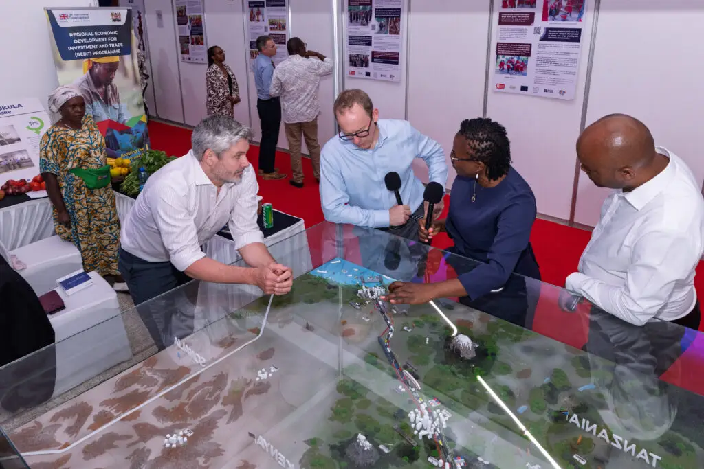 British High Commissioner Matt Baugh (in light blue shirt), alongside TMA CEO David Beer, explore TMA’s model of the Northern Corridor, which traces the journey of goods from the Port of Mombasa to Gulu in northern Uganda, at the British High Commission’s business expo in Mombasa on 13 October 2026.