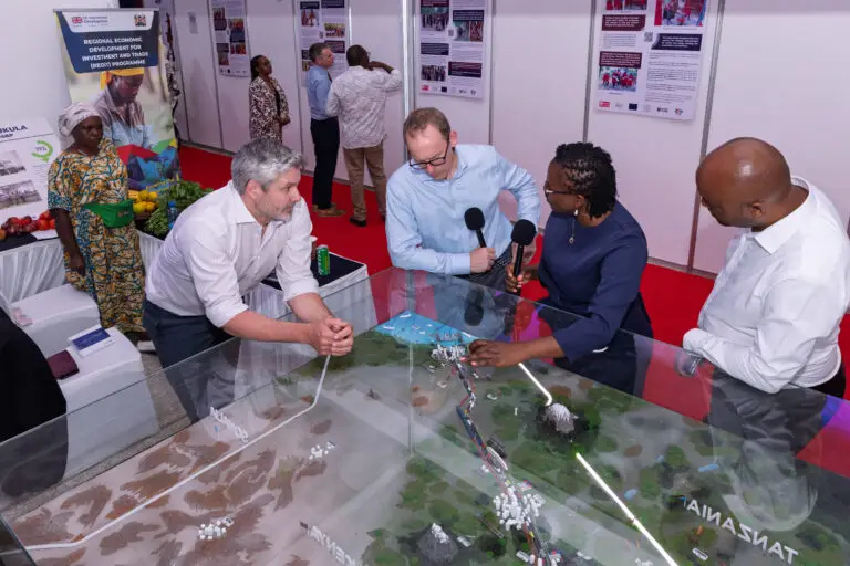 British High Commissioner Matt Baugh (in light blue shirt), alongside TMA CEO David Beer, explore TMA’s model of the Northern Corridor, which traces the journey of goods from the Port of Mombasa to Gulu in northern Uganda, at the British High Commission’s business expo in Mombasa on 13 October 2026.
